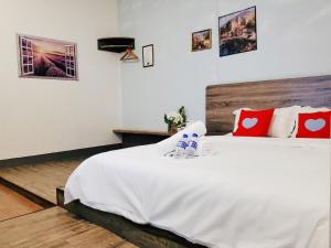 a bedroom with a large white bed with red pillows at Winggarden Murals House by JE Boutique Guesthouse in Ipoh