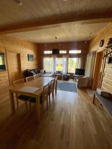 a large living room with a table and chairs at Mukava mökki kompleksi Saimaan rannalla in Mikkeli