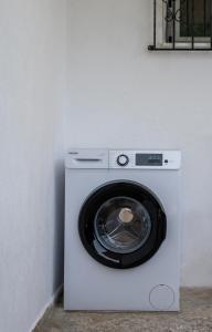 a white washing machine sitting next to a wall at Villa Kali-mera in Sykia Chalkidikis