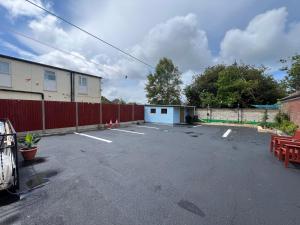 a parking lot with a building and a fence at The Northdale Hotel Ltd in Skegness