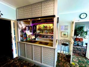 a bar in a room with a clock on the wall at The Northdale Hotel Ltd in Skegness