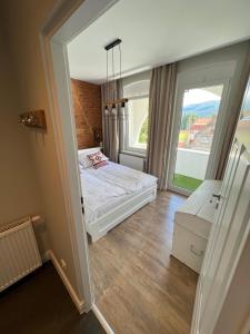 a bedroom with a bed and a large window at Apartament Villa Nelly in Szklarska Poręba