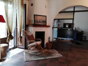 ein Wohnzimmer mit Sessel und Fernseher in der Unterkunft Scacciapensieri's home in Trecastagni