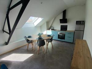 a kitchen and dining room with a table and chairs at La Canopée in La Roche-sur-Yon