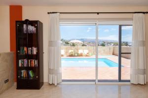 a living room with a book shelf and a sliding glass door at Villa Los Azules with pool and jacuzzi in Maspalomas