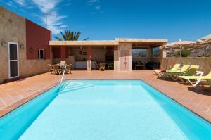 a swimming pool in front of a house at Villa Los Azules with pool and jacuzzi in Maspalomas