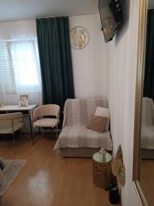 a living room with a bed and a table and a couch at Zelena oaza in Baška Voda