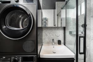 a bathroom with a sink and a washing machine at Riverside City View & free parking in Rzeszów +6 photos