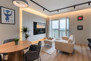 a living room with a table and chairs at Riverside City View & free parking in Rzeszów
