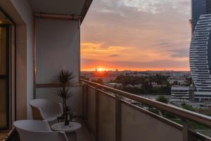 a balcony with a view of the city at sunset at Riverside City View & free parking in Rzeszów