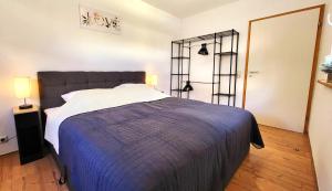a bedroom with a large bed with a blue blanket at Apartment Stadtliebe Marburg PS4 in Marburg an der Lahn