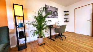 a room with a desk and a chair and a plant at Apartment Stadtliebe Marburg PS4 in Marburg an der Lahn +6 photos
