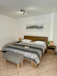 a bedroom with a large bed with a bench next to it at Guest House Renata in Plomin