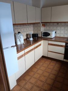 eine Küche mit weißen Schränken und einem Fliesenboden in der Unterkunft Ferienwohnung Aspisheim in Aspisheim