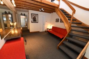 a living room with a staircase with a red couch at Tandapata Boutique Hotel in Cusco +18 photos