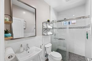 a bathroom with a toilet and a sink and a shower at Stylist Home In Convenient Location! in Temple City +17 photos