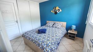 a bedroom with a bed with a blue wall at Le refuge Bleu et Or in Lourdes