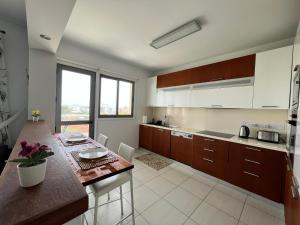 a kitchen with wooden cabinets and a counter top at Queens Boutique Apartment 2BR in Ayios Dhometios +4 photos