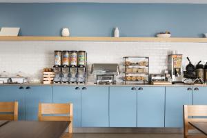 a kitchen with blue cabinets and a counter at Country Inn & Suites by Radisson, Romeoville, IL in Romeoville