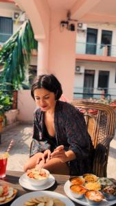 a woman sitting at a table with plates of food at Live Free Hostel Rishikesh in Rishīkesh
