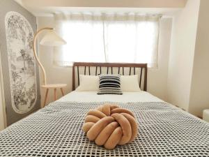 a bed with a large brown bowl on it at 65 两室一厅 駒込站4分 近商业街 2 rooms 4 mins to ST Max 7P 直达新宿 涉谷 表参道 池袋 上野 代代木 银座 原宿 in Tokyo
