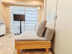 a couch with a pillow on it in a living room at 65 两室一厅 駒込站4分 近商业街 2 rooms 4 mins to ST Max 7P 直达新宿 涉谷 表参道 池袋 上野 代代木 银座 原宿 in Tokyo