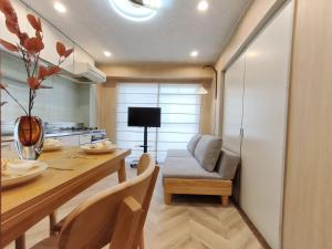 a kitchen and dining room with a table and a couch at 65 两室一厅 駒込站4分 近商业街 2 rooms 4 mins to ST Max 7P 直达新宿 涉谷 表参道 池袋 上野 代代木 银座 原宿 in Tokyo