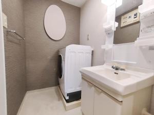 a bathroom with a sink and a white refrigerator at 65 两室一厅 駒込站4分 近商业街 2 rooms 4 mins to ST Max 7P 直达新宿 涉谷 表参道 池袋 上野 代代木 银座 原宿 in Tokyo