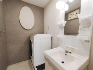 a bathroom with a sink and a white refrigerator at 65 两室一厅 駒込站4分 近商业街 2 rooms 4 mins to ST Max 7P 直达新宿 涉谷 表参道 池袋 上野 代代木 银座 原宿 in Tokyo