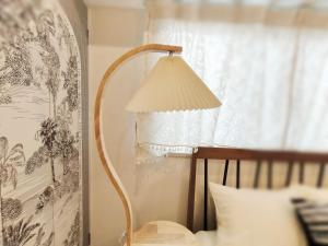 a lamp sitting next to a bed next to a window at 65 两室一厅 駒込站4分 近商业街 2 rooms 4 mins to ST Max 7P 直达新宿 涉谷 表参道 池袋 上野 代代木 银座 原宿 in Tokyo