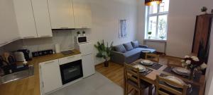 レグニツァにあるApartament Love on 5 - Miłość na 5のキッチンとテーブルのあるリビングルーム