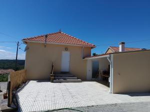 a white house with a door and a porch at Moradia Largo do Pátio in Sertã