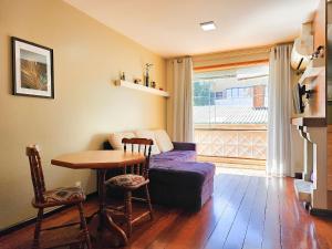 a living room with a couch and a table at Saint Moritz 204 a 2 quadras da Rua Coberta in Gramado