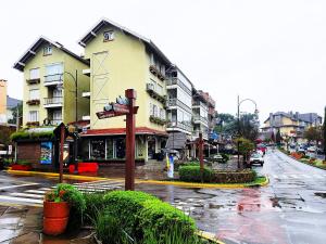a city street with a building on a rainy day at Saint Moritz 204 a 2 quadras da Rua Coberta in Gramado +4 photos