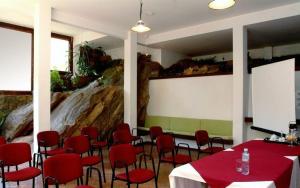 a conference room with red tables and chairs and a screen at Terracota Hotel in Itaipava