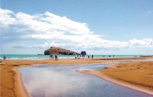 a group of people on a beach with a rock in the water at Morgi in Vieste