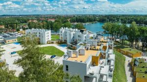 an aerial view of a large white apartment complex next to a river at Apartamenty Stranda Residence nad jeziorem Mazury Holiday in Giżycko +17 photos