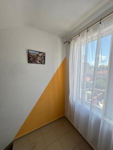 a room with a large window with white curtains at Hotel Laguna - Guest House in Primorsko