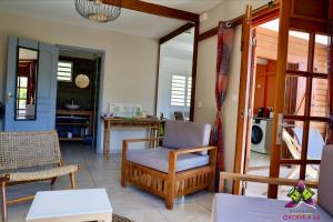 - un salon avec une chaise et une table dans l'établissement Piscine, Plages Bois Jolan et du bourg, Jardin & Parking privés, Sainte-Anne - Villas Orchyd & Ka, à Sainte-Anne