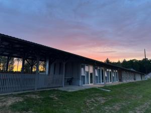a large building with a grass field in front of it at Mūsa Kemping in Bauska +16 photos