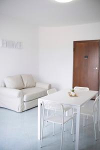 una mesa blanca y sillas en una sala de estar con sofá en Home24, en Casalnuovo di Napoli