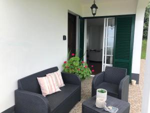 two chairs and a coffee table on a porch at Vivenda Flor in Ponta Delgada