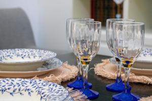 three wine glasses sitting on a table with plates at L'isola felice in Cecina