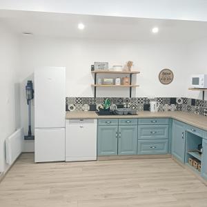 eine Küche mit blauen Schränken und weißen Geräten in der Unterkunft Gîte de la Duranderie in Sevremont