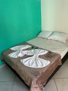 a bed in a room with a green wall at Pousada Você No Guarujá in Guarujá