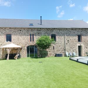 ein großes Steingebäude mit einem Rasen davor in der Unterkunft Gîte de la Duranderie in Sevremont