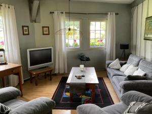 a living room with a couch and a coffee table at Le manège du silence in Bénesville