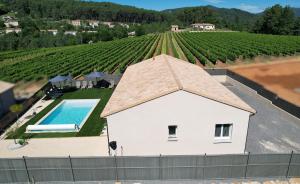an overhead view of a house with a swimming pool and a vineyard at En Ardèche Villa de vacances l'Olympe climatisée avec sa piscine privée et chauffée in Joyeuse