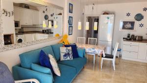 a living room with a blue couch and a table at ELENA flat A little paradise right on the BEACH in Sitio de Calahonda