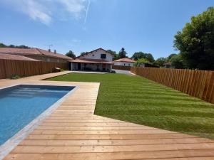 a backyard with a swimming pool and a wooden fence at Artigaous Family in Léon